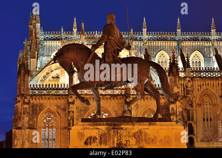 Portogallo: la statua equestre di Nuno Alvares Pereira e vista laterale del Monastero di Batalha di notte Foto Stock