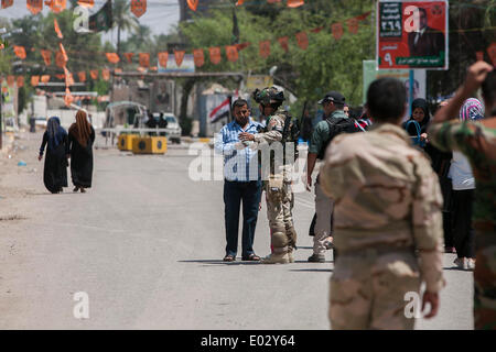 Baghdad in Iraq. 30 apr 2014. Le forze di sicurezza controllare i membri votanti al di fuori di un punto di polling a Baghdad, Iraq, 30 aprile 2014. Dieci persone sono state uccise e 22 altri feriti in attacchi separati di bersagliamento di centri di polling in Iraq il Mercoledì, la polizia ha detto. Credito: cui Xinyu/Xinhua/Alamy Live News Foto Stock