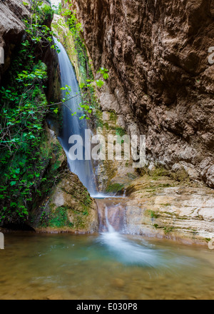 Una piccola cascata profonde nella foresta pluviale, girato in una lunga esposizione Foto Stock