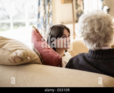 Due donne madre e figlia seduti fianco a fianco di ridere. Foto Stock