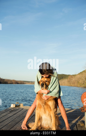Una ragazza di coccole un golden retriever cane. Foto Stock