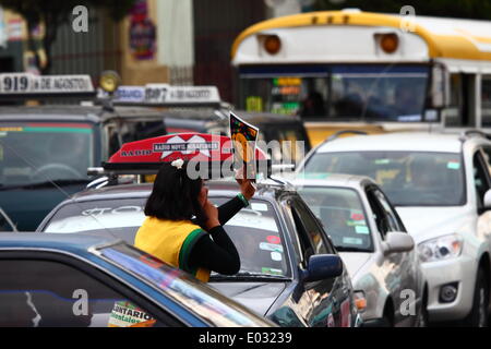 LA PAZ, Bolivia, 30 aprile 2014. Un volontario di gesti al traffico tenendo un dito sulle sue labbra durante n. Avvisatore acustico giorno / Dia de la No Bocina, una campagna per incoraggiare i driver per utilizzare il loro corno inferiore e a ridurre l' inquinamento acustico in città. La Paz è famosa per il suo traffico caotico; il Municipio corre frequentemente le campagne in materia di sicurezza stradale e a ridurre la congestione e simili. Credito: James Brunker / Alamy Live News Foto Stock