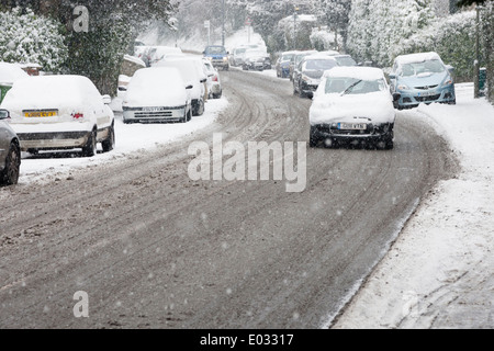 SURREY, Regno Unito il traffico si fa strada lungo strade snowbound vicino a Dorking, Surrey. Foto Stock