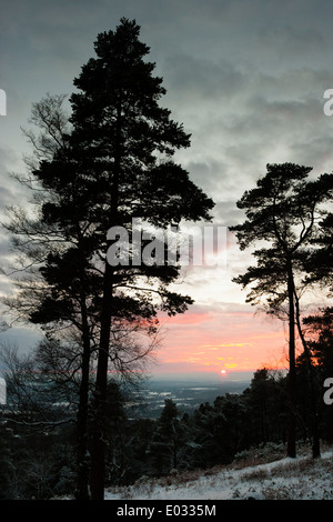 SURREY, Regno Unito set di Sole oltre il paesaggio innevato, Leith Hill. Foto Stock