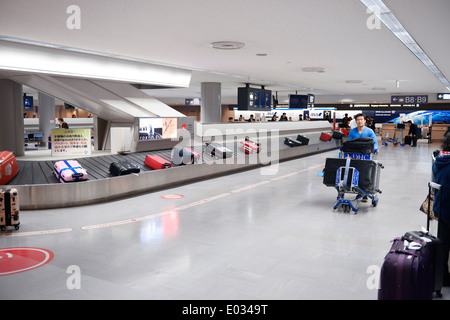 Persone che rivendicano i bagagli all'Aeroporto Internazionale Narita bagaglio trasportatore a giostra, Giappone Foto Stock