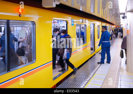 Persone che entrano Tokyo metropolitana treno su una piattaforma. Tokyo, Giappone. Foto Stock