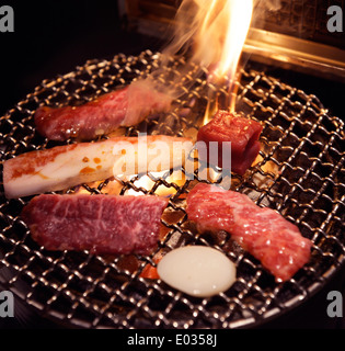 La carne sulla griglia essendo cotta sul fuoco a un giapponese ristorante grill. Yakiniku, Giapponese barbecue. Foto Stock
