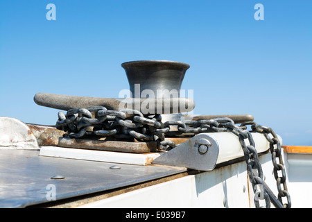 Barche a una catena di ancoraggio viene avvolto e fissato intorno ad un gancio in acciaio come la barca motori attraverso l'oceano. Foto Stock