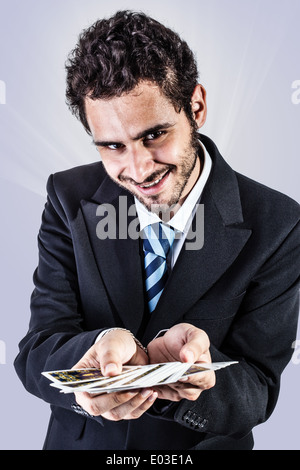 Un elegante giovane imprenditore tenendo un mazzo di carte da gioco Foto Stock