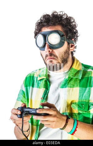 Un ragazzo di indossare un abbigliamento informale e sul vecchio paio di occhiali di protezione su uno sfondo bianco e utilizzando un controller gamepad Foto Stock