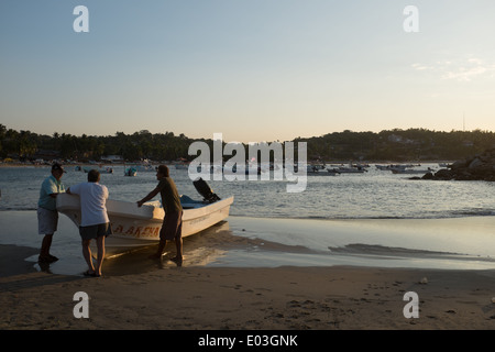 Raccogliere i pescatori sulla spiaggia di mattina presto a Puerto Escondido, Messico. Foto Stock