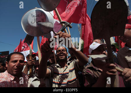La striscia di Gaza, la Palestina. 01 Maggio, 2014. Fatiche palestinese chant slogan come altri tenere ciotole durante il mese di marzo per la Festa del lavoro nella città di Gaza, giovedì 1 maggio 2014. La legge araba, ''La fame ciotola, poveri e affamati, dove è la coscienza, ' secondo l'Ufficio delle Nazioni Unite per il Coordinamento degli Affari Umanitari, il tasso di disoccupazione nella Striscia di Gaza è uno dei più alti del mondo. Credito: ZUMA Press, Inc./Alamy Live News Foto Stock