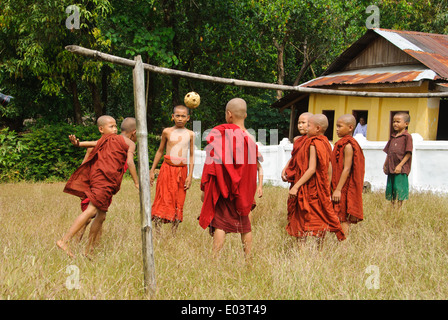 Novizi buddisti stanno giocando takraw davanti a un tempio. Foto Stock