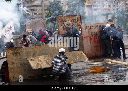 Istanbul, Turchia. Il 1 maggio, 2014. I dimostranti prendere la copertura come polizia fire gas lacrimogeni per disperdere i manifestanti a Istanbul, in Turchia, il 1 maggio 2014. Sommossa la polizia ha sparato gas lacrimogeni e pallottole di gomma e cannoni acquatici giovedì su manifestanti che hanno sfidato un divieto ufficiale a marzo verso l'iconica Piazza Taksim di Istanbul, la più grande città della Turchia. Credito: Cihan/Xinhua/Alamy Live News Foto Stock