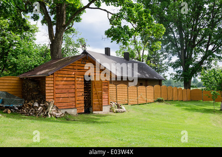 Schede laccato a mano legnaia in cantiere villaggio lungo alta recinzione di legno Foto Stock