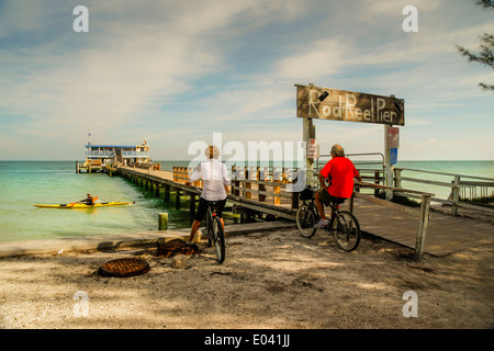 Due persone su biciclette presso la canna e mulinello Pier stop per godersi la vista su Anna Maria Island, Florida Foto Stock