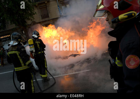 Barcellona, Spagna - 1 Maggio, 2014. I pompieri spengono bruciando spazzatura. Un anti-capitalista manifestazione tenutasi a Barcellona in occasione del giorno di maggio si è conclusa con la sommossa a causa di un piccolo gruppo di persone che ha rotto la banca uffici, bruciato spazzatura e hanno attaccato alcuni fotografi che hanno coperto la dimostrazione. Credito: Jordi Boixareu/Alamy Live News Foto Stock