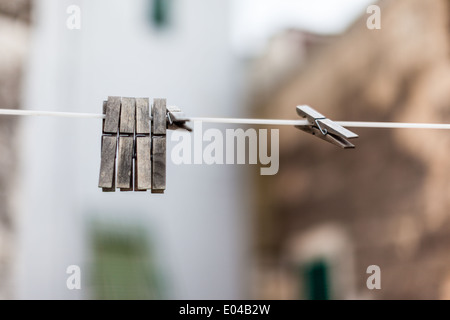 Alcuni vecchi e weathered mollette impiccato su un whire Foto Stock