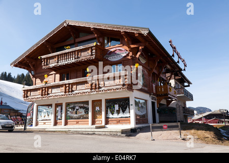 Chalet-style Ski shop, ristorante e hotel, dal lato della pista, nella località sciistica di Les Gets, Francia. Foto Stock