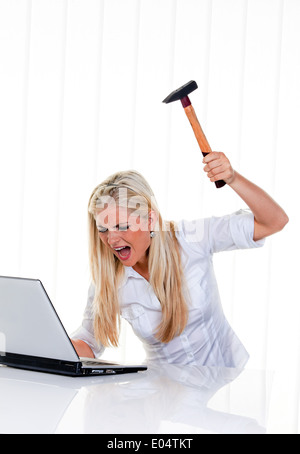 Donna con computer a del problema, il martello e il laptop:, Frau mit Computer Problemen, martello und laptop: Foto Stock