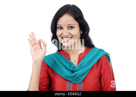 Ritratto di una giovane donna che fa il gesto OK contro uno sfondo bianco Foto Stock