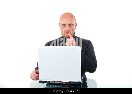 Scioccato uomo al lavoro con il suo computer portatile isolato su bianco Foto Stock