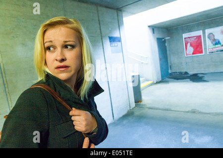 Una giovane donna in un sottopasso per pedoni è paura di fastidio e di attività criminale, Eine junge Frau in einer Unterfuehrun Foto Stock
