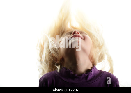 Foto di stock di una bimba di 8 anni, scuotendo i capelli biondi Foto Stock