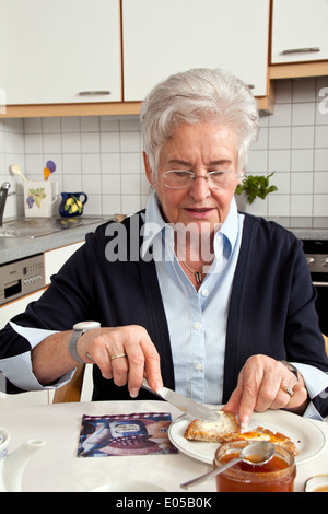 Vecchio infermiere senior aiuta nella colazione, Altenpflegerin Seniorin hilft beim Fruehstueck Foto Stock