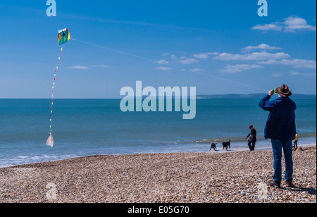 L'uomo volare un aquilone su una spiaggia a Bournemouth, baia di Poole, Dorset, Inghilterra, Regno Unito. Foto Stock