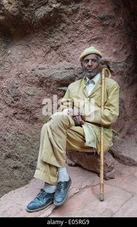 Il vecchio uomo appoggiato nel passaggio verso la tomba di Adam in Lalibela, Etiopia Foto Stock