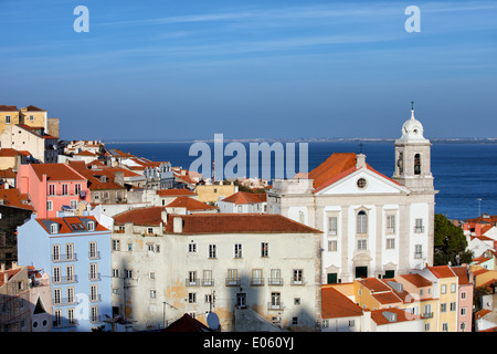 La città di Lisbona in Portogallo, vista sul quartiere di Alfama, Santo Estevao chiesa sulla destra del fiume Tagus in background. Foto Stock