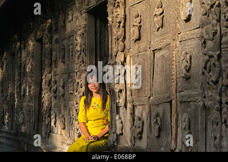 Ragazza dalla porta di legno nel monastero Shwenandaw, noto anche come l'ex Palazzo Reale fatta di legno, Mandalay Myanmar Foto Stock