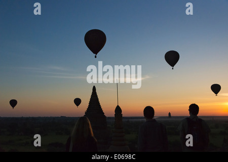 Tourist i palloni ad aria calda su antichi templi e pagode nella giungla di sunrise, Bagan, Myanmar Foto Stock