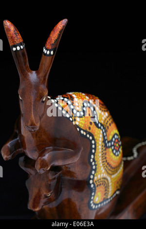 Una scultura in legno di un canguro australiano decorata con colorate aboriginal dot pittura, su uno sfondo nero. Negozio di souvenir. Foto Stock