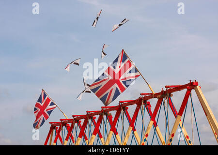 Weymouth, Regno Unito. 04th maggio, 2014. I visitatori si riuniscono per guardare la varietà di aquiloni colorati ballare con la musica nel cielo al Weymouth Kite Festival - aquiloni che volano sopra le bandiere di Union Jack sulle altalene altalene altalena altalena. Credit: Carolyn Jenkins/Alamy Live News Foto Stock