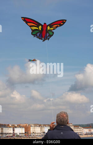 Weymouth, Regno Unito. 04th maggio, 2014. I visitatori si riuniscono per guardare la varietà di aquiloni colorati ballare con la musica nel cielo al Weymouth Kite Festival Man volare aquiloni colorati farfalla. Credit: Carolyn Jenkins/Alamy Live News Foto Stock
