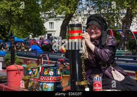 Londra, Regno Unito. Il 4 maggio, 2014. Una donna in abito vittoriano leviga il brass sul suo narrowboa presso la cavalcata Canalway, Little Venice, Londont. Credito: Paolo Davey/Alamy Live News Foto Stock