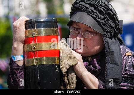 Londra, Regno Unito. Il 4 maggio, 2014. Una donna in abito vittoriano leviga il bronzo su ther narrowboat presso la cavalcata Canalway, Little Venice, a Londra. Credito: Paolo Davey/Alamy Live News Foto Stock