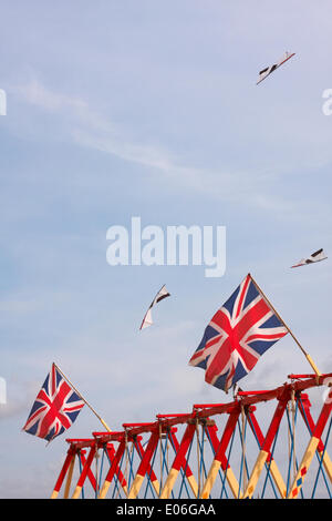 Weymouth, Regno Unito. 04th maggio, 2014. I visitatori si riuniscono per guardare la varietà di aquiloni colorati ballare con la musica nel cielo al Weymouth Kite Festival - aquiloni che volano sopra le bandiere di Union Jack sulle altalene altalene altalena altalena. Credit: Carolyn Jenkins/Alamy Live News Foto Stock