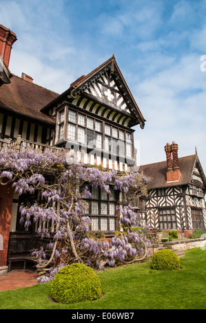 Vista del National Trust-owned Wightwick Manor, in Wolverhampton, con splendida fioritura glicine che copre l'ala ovest Foto Stock