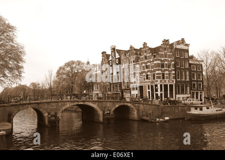 Ponte e vecchie case dove Prinsengracht incontra Bouwersgracht canal in Amsterdam, quartiere Jordaan, Paesi Bassi (seppia edit) Foto Stock