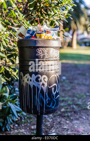 Un troppo pieno e di vandalismo nel cestino in un parco Foto Stock