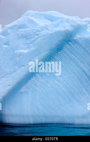 Iceberg che mostra direttamente le linee a strisce e linea di acqua erosione nei pressi de Cuverville Island Antartide Foto Stock