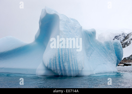 Iceberg con marcature di linea e la linea di galleggiamento erosione nei pressi de Cuverville Island Antartide Foto Stock
