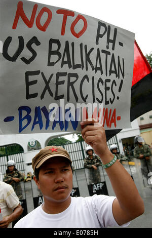 (140505) -- la città di Quezon, 5 maggio 2014 (Xinhua) -- Un attivista detiene una targhetta nella parte anteriore dei soldati filippini durante una manifestazione di protesta contro la difesa rafforzata cooperazione (EDCA) fuori dai cancelli delle forze armate delle Filippine (AFP) sede a Camp Aguinaldo a Quezon City, Filippine, 5 maggio 2014. Gli attivisti si condanna la EDCA, in cui gli Stati Uniti avranno una maggiore presenza di rotazione nelle Filippine e avrà un maggiore accesso ai porti del paese, aerodromi e basi militari. I dimostranti sono anche protestare contro la Balikatan 2014, WH Foto Stock