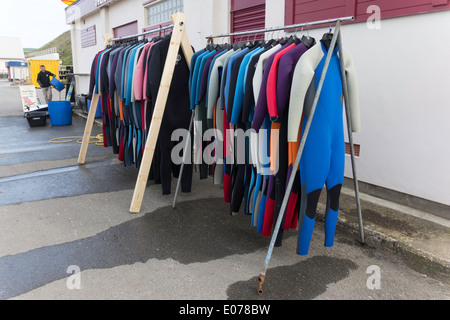 Saltburn Scuola Surf edificio sul lungomare con mute appendere fuori ad asciugare Foto Stock