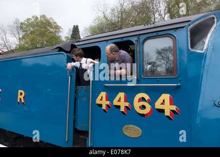 Equipaggio guardare la piattaforma come il treno trainato da Loocomotive 4464 Tarabuso arriva prima gara al NYMR stazione a Goathland Foto Stock