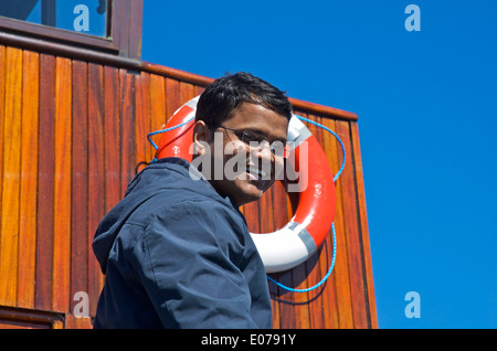 Giovane uomo asiatico godendo di viaggio su mv Teal, un 'steamer' azionato da Windermere crociere sul lago, Lake District, Cumbria, England Regno Unito Foto Stock