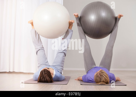 Le donne a fare pratica con palle ginniche sulla classe di Pilates Foto Stock